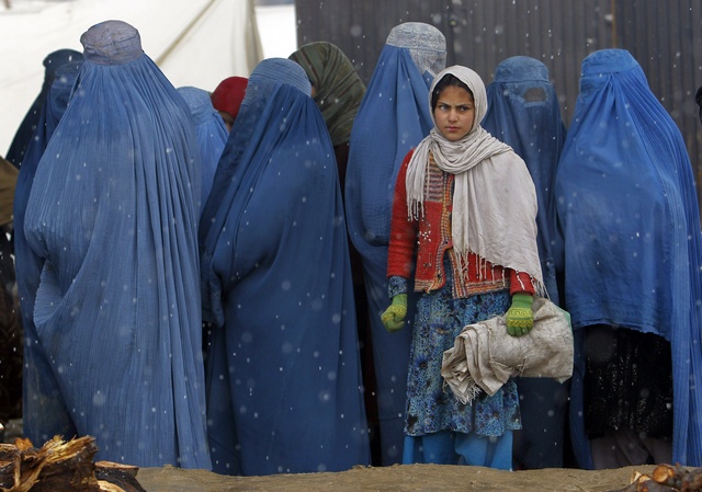 Afghan women wait to receive winter relief assistance donated by the Danish Refugee Council (DRC) in the outskirts of Kabul on February 3, 2013. © 2013 Reuters